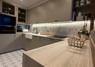 Cocina lacada moldurada con desayunador y vitrinas iluminadas